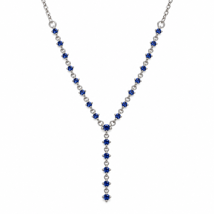 A silver Y-necklace featuring deep blue round-cut gemstones and small clear accent stones, displayed on a solid white background.