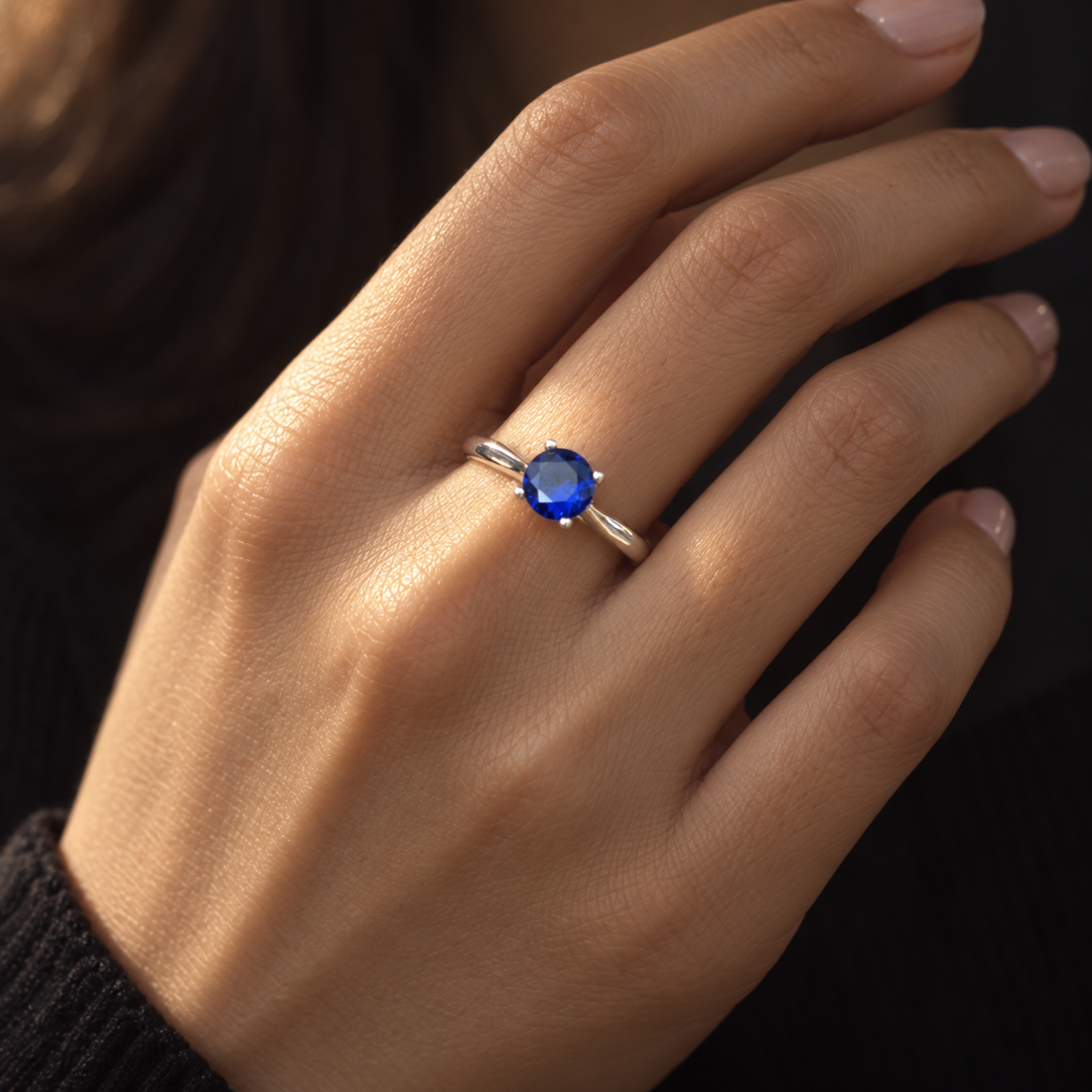 Woman wearing a blue round-cut CZ silver solitaire ring
