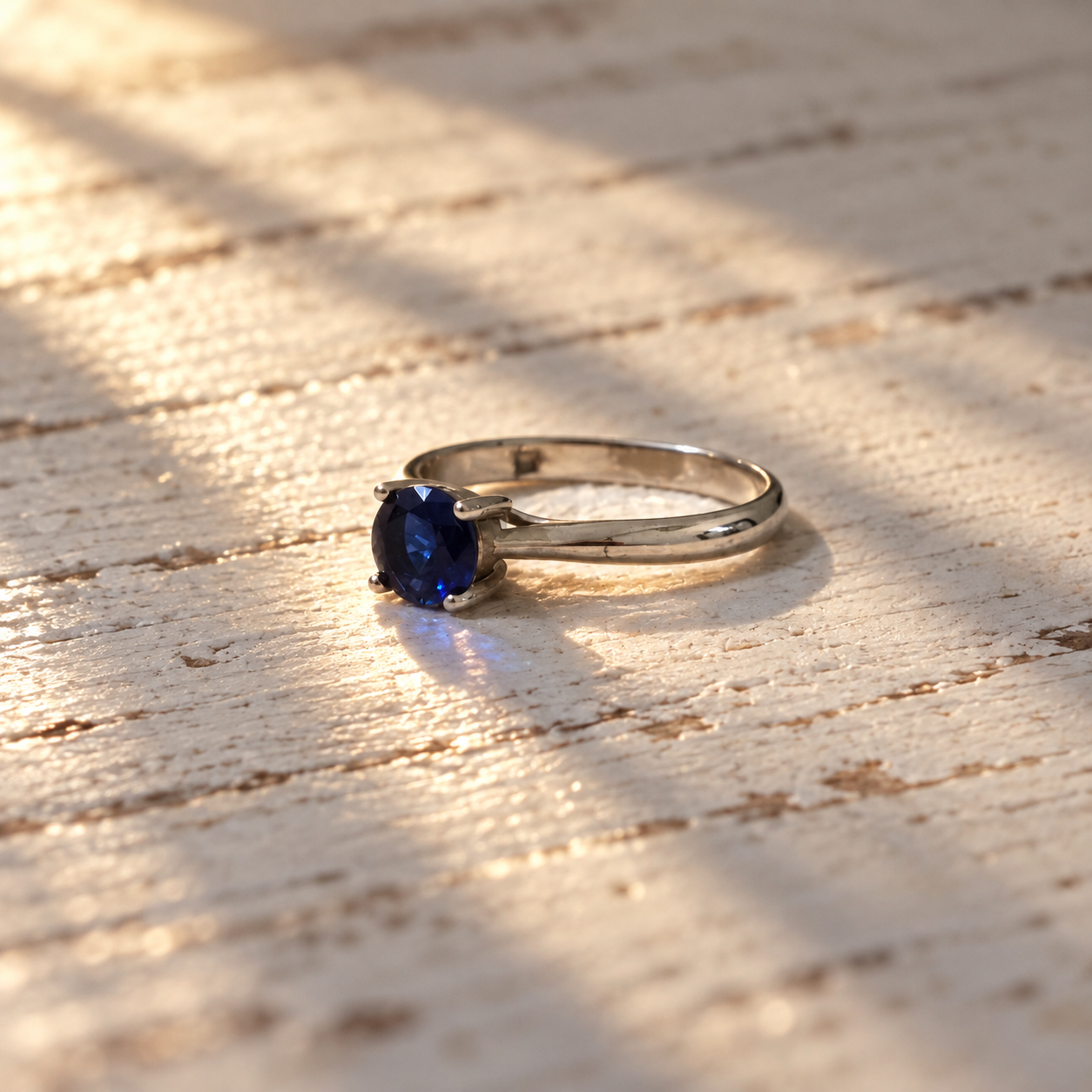 Side view of royal-blue CZ solitaire ring with polished silver band
