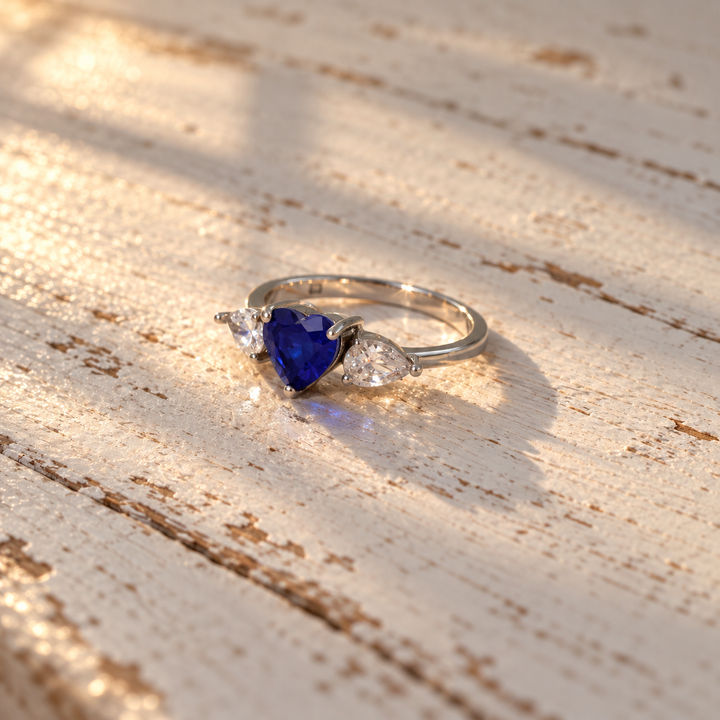 Blue heart CZ ring with clear pear-cut side stones
